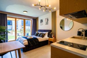 sypialnia z łóżkiem i kanapą w pokoju w obiekcie Podhalańskie Uroki by Apart Concept Podhale w mieście Kościelisko