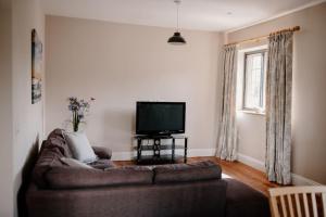 a living room with a couch and a flat screen tv at The Courtyard at Manor Estate near Stonehenge in Salisbury