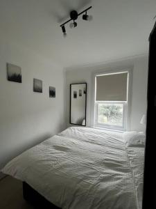 Seven KingsにあるCosy one-bedroom furnished flat!の白いベッドルーム(大型ベッド1台、窓付)
