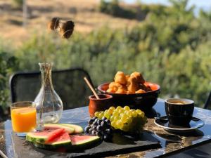 a table with a plate of fruit and a bowl of food at Dim's Hotel & Restaurant in Korçë