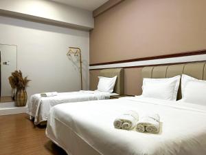 a hotel room with two beds with towels on them at Mana Mana Hotel • Melaka • in Melaka