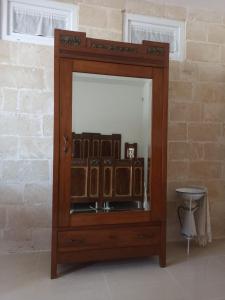 a wooden cabinet with a mirror in a room at Il Vecchio Mulino in Modugno
