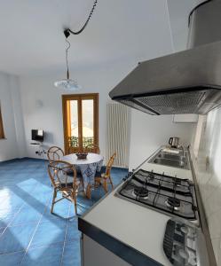 a kitchen with a stove and a table with chairs at Antica Porta Residence, in the center of Ravello, 3 min walk within Villa Rufolo and the main Square in Ravello