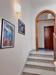 a hallway with stairs with a door and a picture on the wall at Antica Porta Residence, in the center of Ravello, 3 min walk within Villa Rufolo and the main Square in Ravello