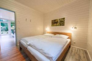 sypialnia z dużym łóżkiem z białą pościelą w obiekcie "Ferienhaus-Lichtung" Ihr exklusives Waldchalet im grünen Herzen von Deutschland w mieście Ruhla
