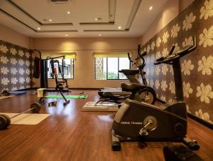 un gimnasio con cintas de correr y equipos de ejercicio en una habitación en The Greenwood - Tezpur, en Tezpur