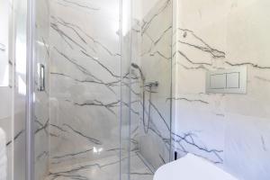 a bathroom with a shower with a glass door at Apartments Janko Zarok in Baška