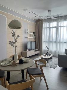 ein Wohnzimmer mit einem Tisch, Stühlen und einem TV in der Unterkunft Theda Antara Putrajaya with Wifi and Netflix in Putrajaya
