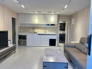 uma sala de estar com um sofá e uma cozinha em Guesthouse in a villa North Shore minutes from CBD em Auckland