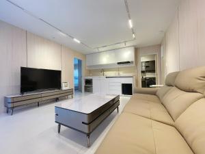 uma sala de estar com um sofá e uma televisão em Guesthouse in a villa North Shore minutes from CBD em Auckland