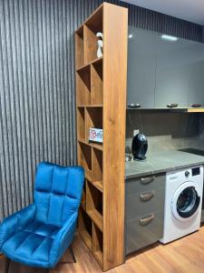 une chaise bleue dans une cuisine avec lave-linge dans l'établissement WEST POINT DELUXE SUITE, à Plovdiv