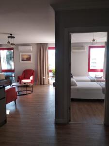 uma sala de estar com uma cama e uma cadeira vermelha em City Center House em Antalya