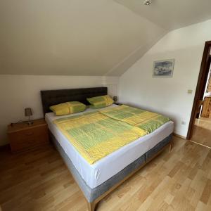 a bedroom with a bed with yellow and green sheets at Ferienwohnungen Am Park in Bad Steben