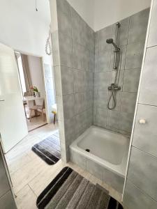 un bagno con doccia e vasca da bagno di PEBBLE Apartman ZADAR a Zara (Zadar)