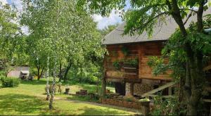 a log cabin in the middle of a yard with trees at Log cabin in Belgrade