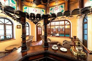 Regent Club Vila Tereza في ترينتشياسكي تيبليسي: غرفة طعام مع طاولة وكراسي ونوافذ