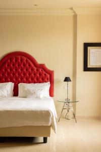 a bedroom with a large red headboard and a table at Alvino Relais Mulino Contemporaneo in Matera
