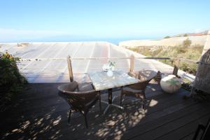 een tafel en stoelen op een terras met uitzicht op de oceaan bij Charmantes, kleines Ferienhaus mit Terrasse für zwei Personen in Guía de Isora