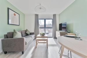 ein Wohnzimmer mit einem Sofa und einem Tisch in der Unterkunft Modern 1 Bed Apartment, Nightingale Quarter Derby in Derby