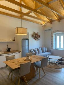 ein Wohnzimmer mit einem Tisch und einem Sofa in der Unterkunft Mangata suites homes with private pools in Meganisi