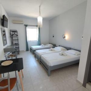 a room with three beds and a table and a desk at Antonia in Galissas