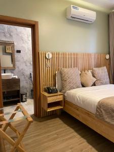 a bedroom with a bed and a bathroom with a sink at Saphir Boutique Hotel in Kigali