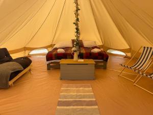 Damson Bell Tent في درويتويتش: غرفة مع خيمة مع سرير وطاولة