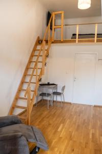 een woonkamer met een tafel en een trap bij Gemütliches Studio mit Hochbett im Herzen von Graz in Graz