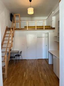 een kamer met een trap, een tafel en een bureau bij Gemütliches Studio mit Hochbett im Herzen von Graz in Graz