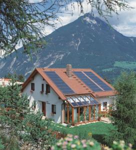 a house with solar panels on the roof at Ferienwohnung mit Weinlaube in Imst mit Terrasse, Grill und Garten in Imst