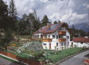 a house with a garden in front of it at Ferienwohnung mit Weinlaube in Imst mit Terrasse, Grill und Garten in Imst