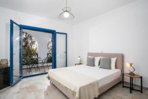 a bedroom with a bed and a balcony with a table at Villa Kaya in Haraki