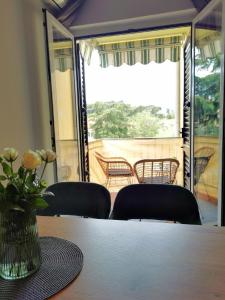 eine Vase mit Blumen auf einem Tisch mit Stühlen in der Unterkunft Studio für 4 Personen ca 37 qm in Rovinj, Istrien Istrische Riviera in Rovinj