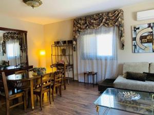 ein Wohnzimmer mit Tisch und ein Esszimmer in der Unterkunft Liebevoll eingerichtetes Ferienhaus mit Meerblick von der schönen Dachterrasse und eigenem Obstgarten in Las Galletas + 14 Fotos