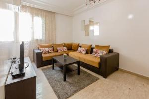 - un salon avec un canapé et une table dans l'établissement Bel appartement au centre de Casa, à Casablanca