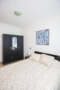 - une chambre avec un grand lit et une armoire noire dans l'établissement Bel appartement au centre de Casa, à Casablanca