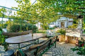 een patio met een houten tafel en 2 banken bij Appartement in Kapelica, Istria County mit Privatem Pool in Labin
