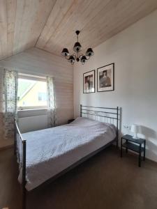 a bedroom with a bed and a large window at Metal-House in Vievis