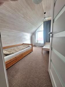 Pokój z łóżkiem, oknem i drzwiami w obiekcie Metal-House w mieście Vievis