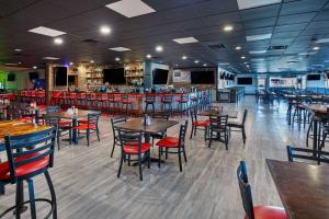 a restaurant with tables and chairs and a bar at Ramada by Wyndham Bowling Green in Bowling Green