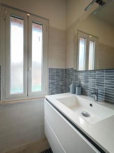 Baño blanco con lavabo y espejo en San Vincenzo, en Tívoli