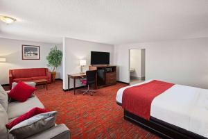 a hotel room with a bed a desk and a tv at Ramada by Wyndham Bowling Green in Bowling Green