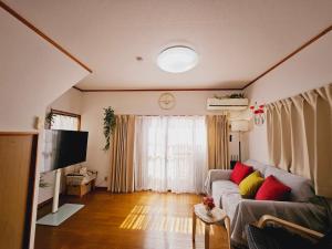 a living room with a couch and a television at AsahiStay -Koiwa, Free parking O, Whole Family House, Japanese garden taste in Tokyo