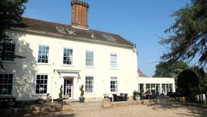a white building with a brick chimney on top at Best Western Priory Hotel in Bury Saint Edmunds