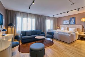 Habitación de hotel con cama y sofá en Scandic Star Sollentuna, en Sollentuna