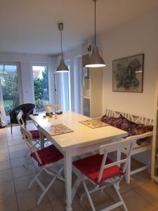 a dining room with a white table and chairs at Ferienhaus am Salzhaff in Boiensdorf