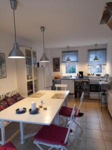 a kitchen and living room with a white table and chairs at Ferienhaus am Salzhaff in Boiensdorf