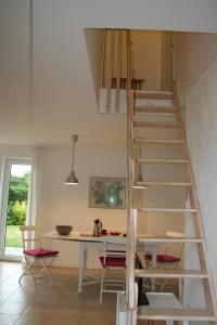 a white staircase in a room with a table and chairs at Ferienhaus am Salzhaff in Boiensdorf +16 photos