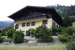 una casa con techo negro en una colina en Geräumig ausgelegte Ferienwohnung in der oberen Etage mit Bergblick vom privaten Balkon - b57486, en Bruck an der Großglocknerstraße