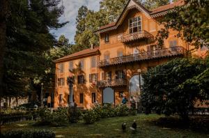 a large building with people walking in front of it at Villaggio Narrante - Le Case dei Conti Mirafiore in Serralunga d'Alba
